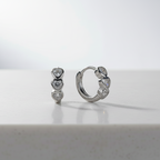 Pair of silver hoop earrings with heart-shaped CZ
